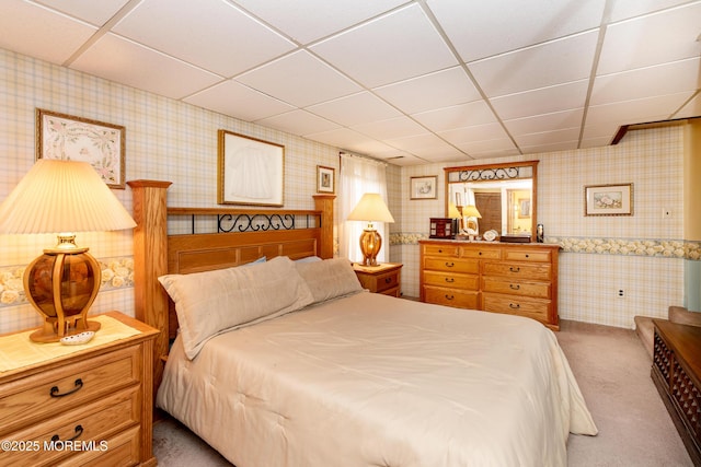 carpeted bedroom with a drop ceiling and wallpapered walls