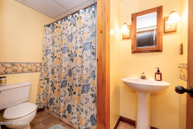 full bathroom with a paneled ceiling, toilet, a sink, and a shower with shower curtain