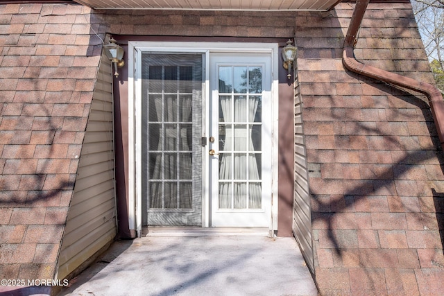 property entrance with roof with shingles