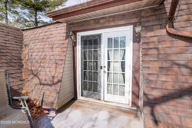 entrance to property with a shingled roof