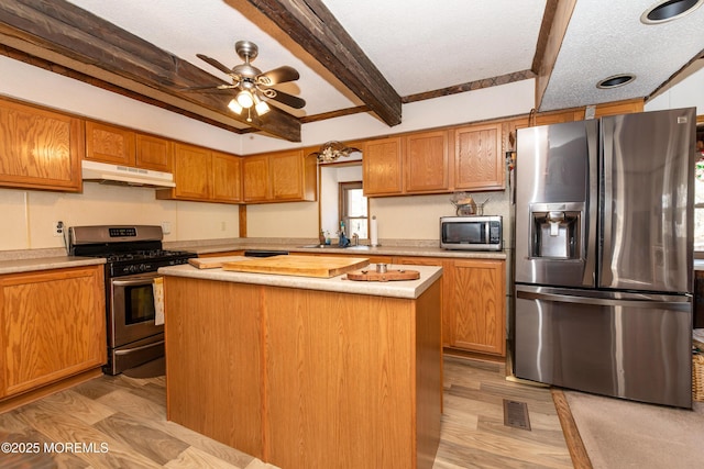 kitchen with light wood-style floors, a kitchen island, appliances with stainless steel finishes, light countertops, and under cabinet range hood