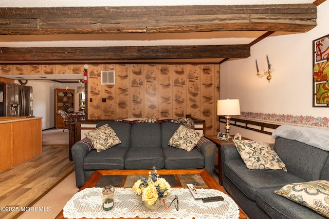 living room featuring visible vents, beamed ceiling, and wood finished floors