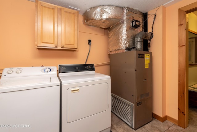 laundry area with cabinet space, light tile patterned floors, heating unit, a textured ceiling, and washer and dryer