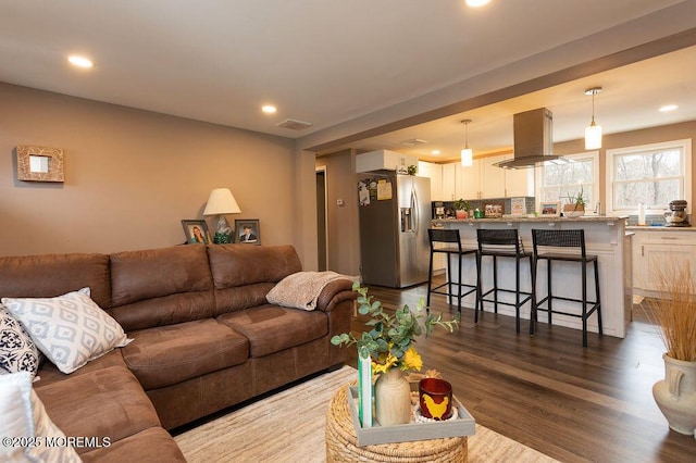 living area with dark wood-type flooring, recessed lighting, and visible vents