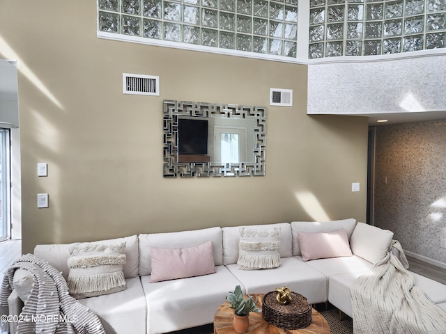 living area featuring visible vents and wood finished floors