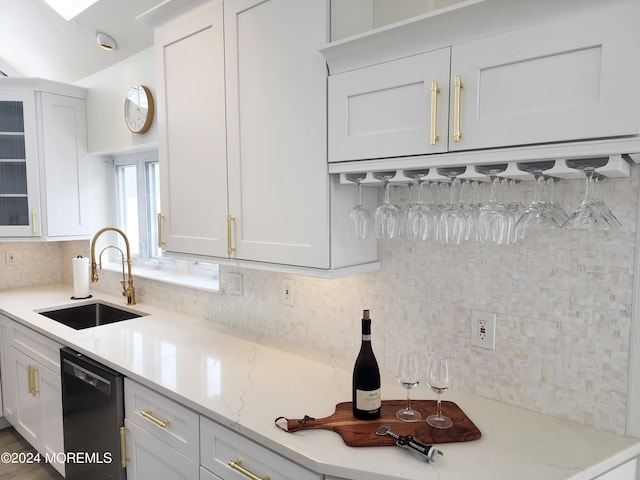 kitchen with a sink, white cabinetry, black dishwasher, decorative backsplash, and glass insert cabinets