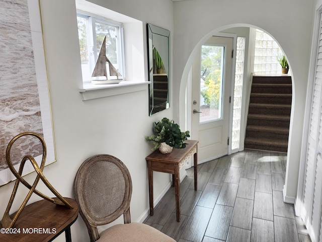 foyer entrance with baseboards, stairway, and wood finish floors