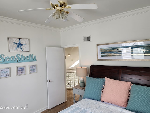 bedroom with ornamental molding, wood finished floors, visible vents, and a ceiling fan