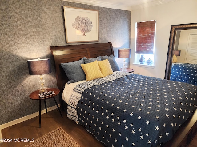 bedroom with crown molding, wood finished floors, and baseboards