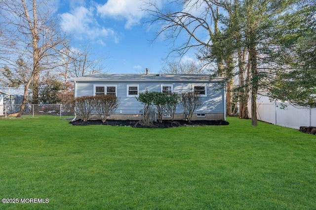 rear view of property featuring a fenced backyard and a yard