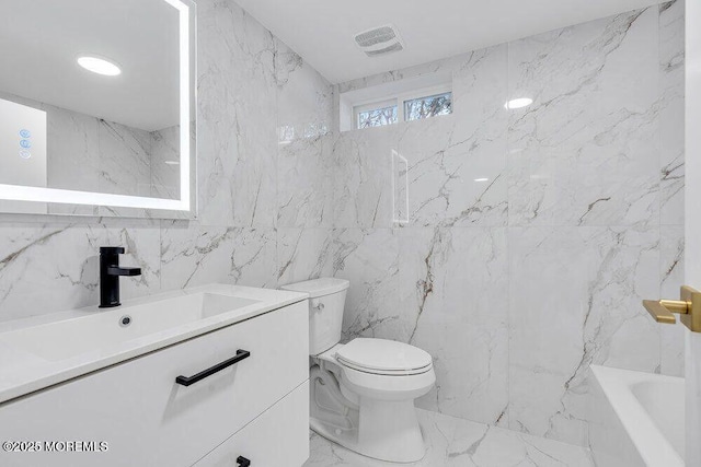 bathroom with a bathing tub, visible vents, toilet, and stone wall