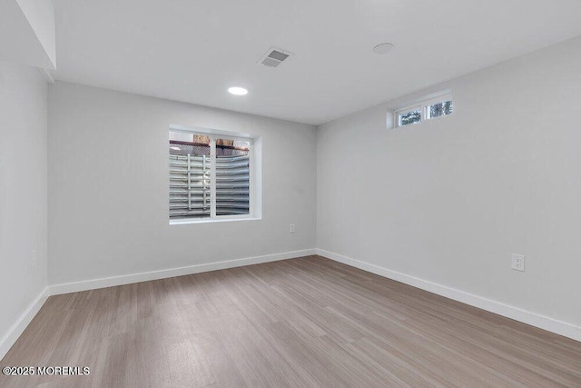 spare room featuring visible vents, baseboards, and wood finished floors