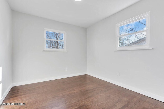 empty room featuring dark wood-style flooring and baseboards