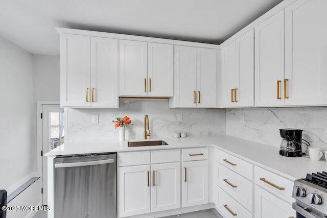 kitchen with light countertops, backsplash, appliances with stainless steel finishes, white cabinets, and a sink