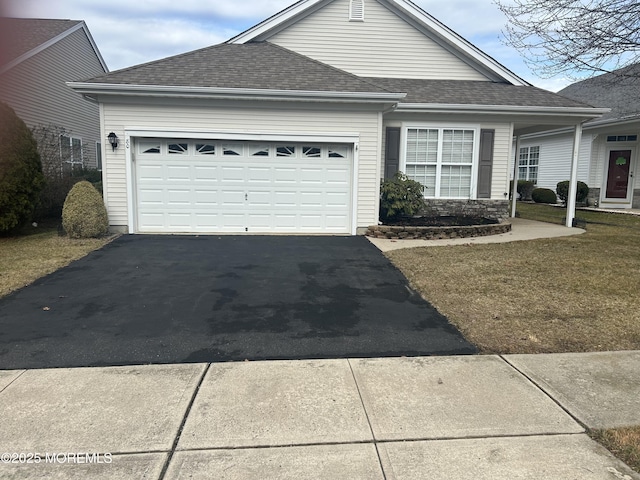 view of front of property featuring roof with shingles, driveway, and an attached garage