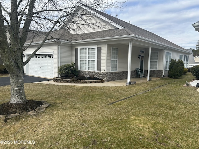 view of front of house featuring roof with shingles, a garage, stone siding, driveway, and a front lawn