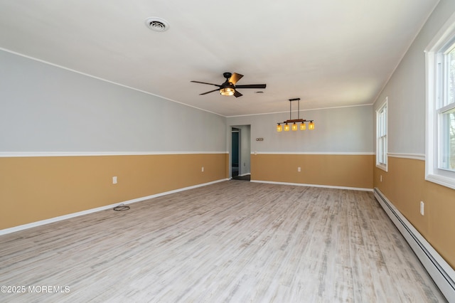 spare room with visible vents, baseboards, ceiling fan, baseboard heating, and light wood-style flooring