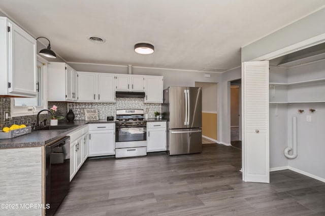 kitchen with visible vents, under cabinet range hood, a sink, dark countertops, and stainless steel appliances