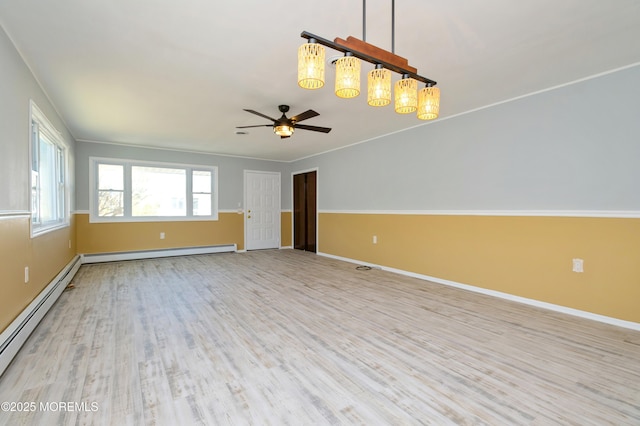 unfurnished living room with a baseboard heating unit, light wood-type flooring, baseboards, and a baseboard radiator