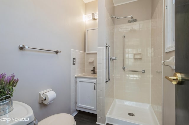 bathroom with vanity, toilet, and tiled shower