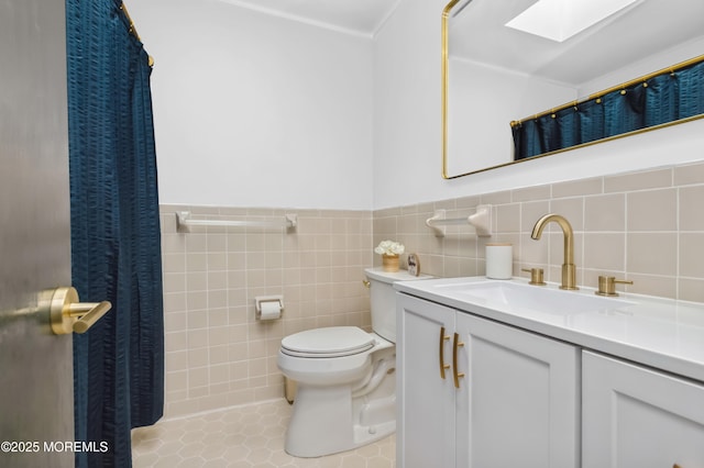 full bathroom featuring tile walls, toilet, a skylight, tile patterned floors, and vanity