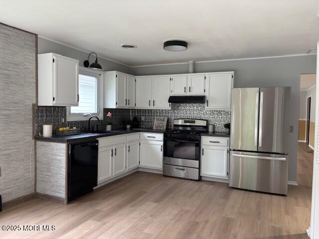 177 Freeport Blvd, Toms River, NJ 08757 - kitchen with appliances with stainless steel finishes, under cabinet range hood, dark countertops, white cabinets, and crown molding