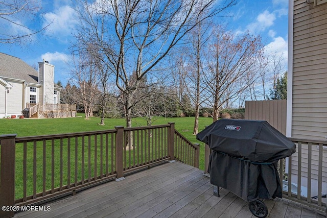 wooden terrace featuring grilling area and a lawn