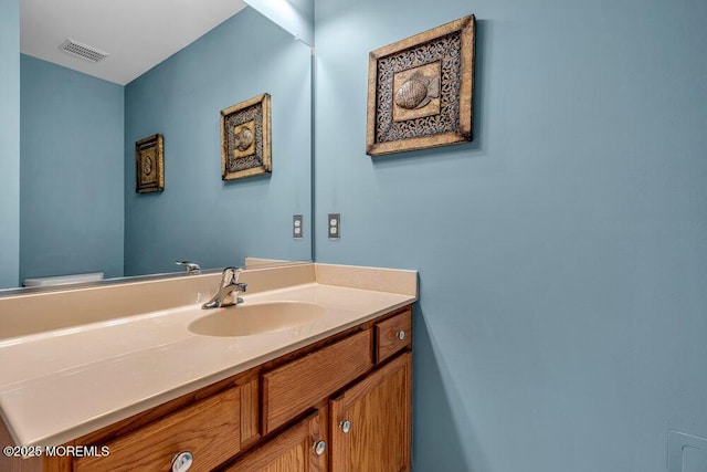 bathroom featuring visible vents, toilet, and vanity