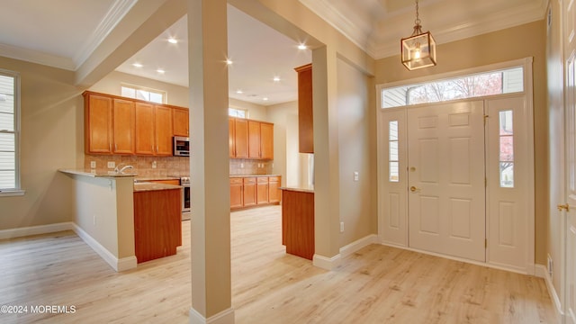 entryway with recessed lighting, baseboards, crown molding, and light wood finished floors