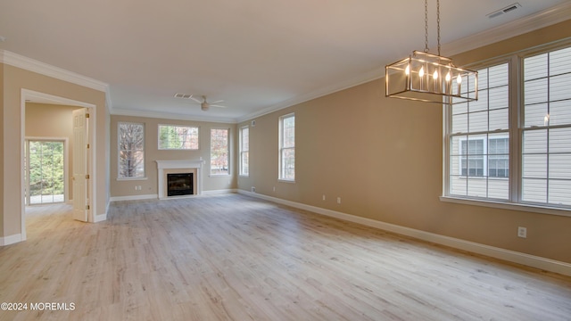 unfurnished living room featuring baseboards, visible vents, a glass covered fireplace, ornamental molding, and wood finished floors