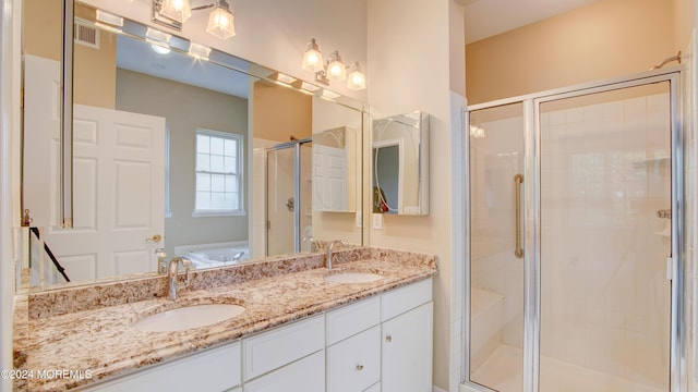 bathroom with a stall shower, visible vents, a sink, and double vanity