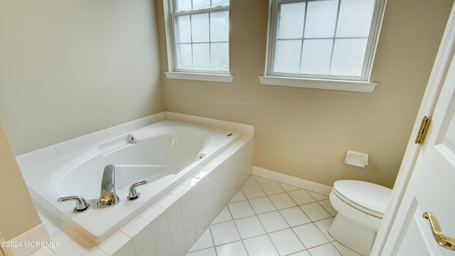 bathroom featuring tile patterned flooring, a garden tub, toilet, and baseboards