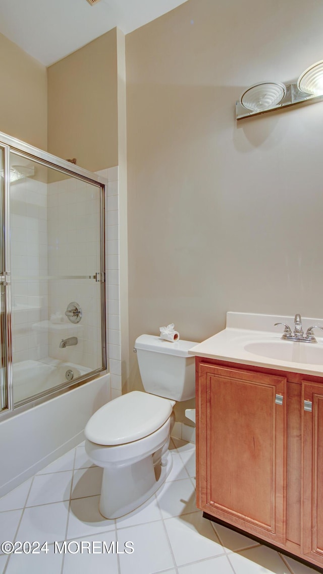 full bath with tile patterned flooring, combined bath / shower with glass door, vanity, and toilet