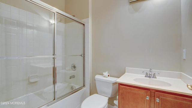 bathroom featuring enclosed tub / shower combo, vanity, and toilet