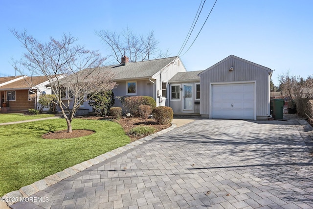 single story home featuring a front lawn, decorative driveway, roof with shingles, an attached garage, and a chimney