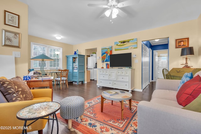 living room featuring baseboards, dark wood finished floors, and a ceiling fan