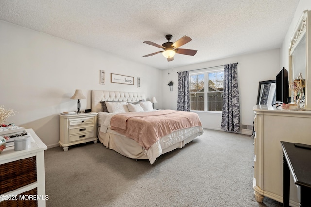 bedroom featuring baseboards, visible vents, ceiling fan, a textured ceiling, and light carpet