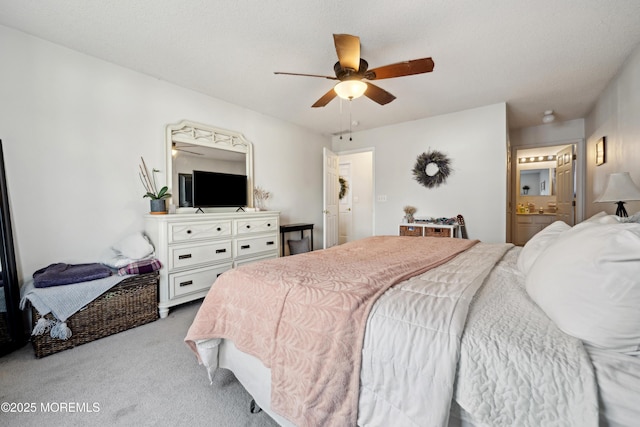 carpeted bedroom featuring a ceiling fan and ensuite bathroom