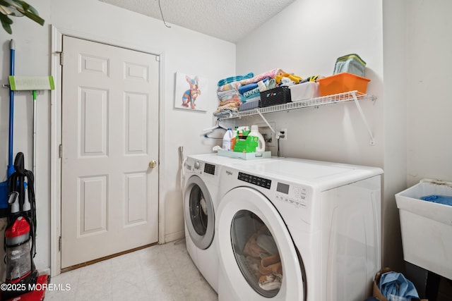 clothes washing area featuring a sink, separate washer and dryer, laundry area, and a textured ceiling