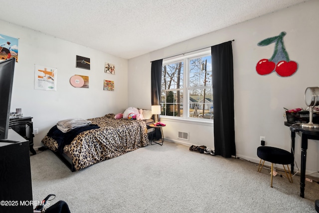 carpeted bedroom featuring visible vents, a textured ceiling, and baseboards