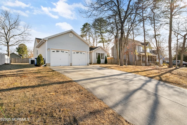 view of front of property with cooling unit, driveway, an attached garage, and fence