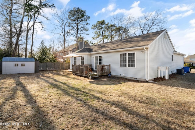 rear view of property with an outbuilding, fence, a shed, a chimney, and a deck