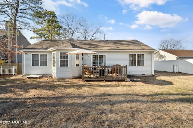 rear view of house featuring crawl space, a lawn, a wooden deck, and fence