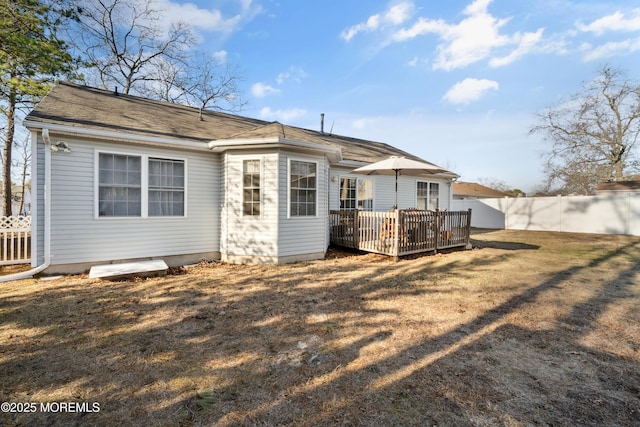 back of house with a lawn, a deck, and fence