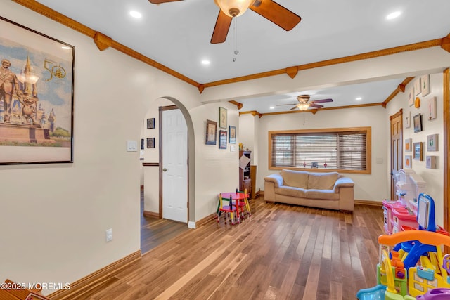 game room featuring wood finished floors, recessed lighting, arched walkways, crown molding, and baseboards