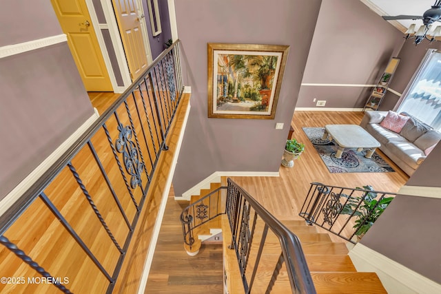 stairway with visible vents, wood finished floors, and baseboards