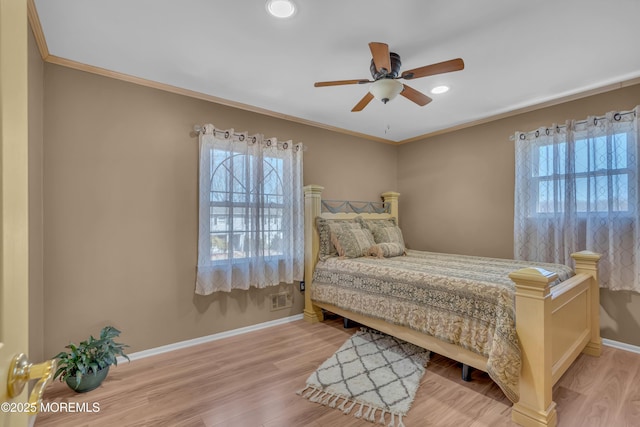 bedroom featuring wood finished floors, baseboards, and ornamental molding