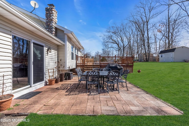 view of patio / terrace featuring an outbuilding, outdoor dining area, and a deck