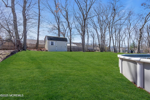 view of yard with a storage unit, an outbuilding, and a fenced backyard