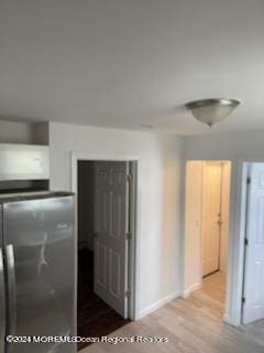 hallway featuring baseboards and wood finished floors